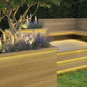 Modern outdoor seating area and decking with illuminated planters and decorative plants.