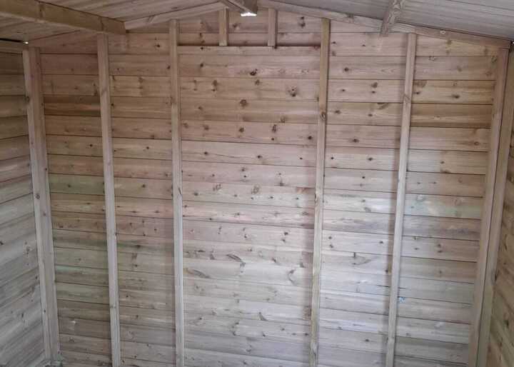 Interior of a wooden shed with bare wooden walls and floor.