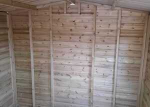 Interior of a wooden shed with bare wooden walls and floor.