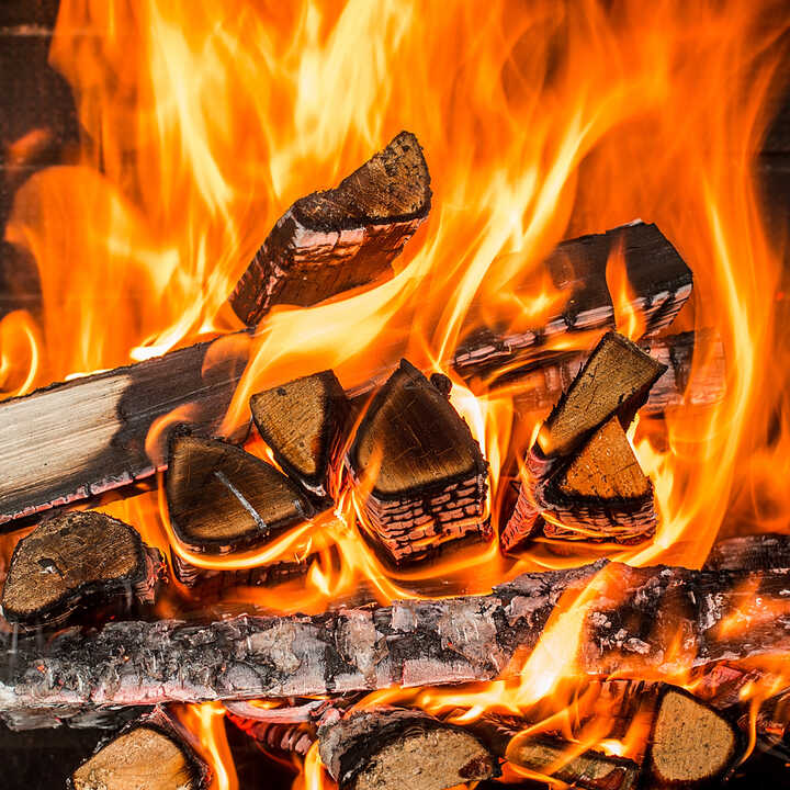 Flames and glowing embers from a wood fire in a fireplace.