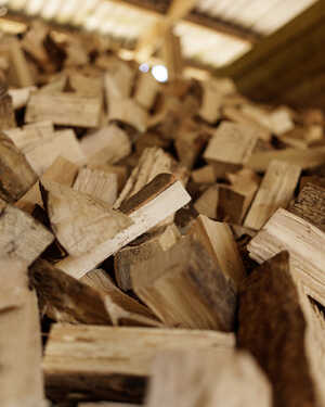 A close-up of stacked firewood pieces in a shed.