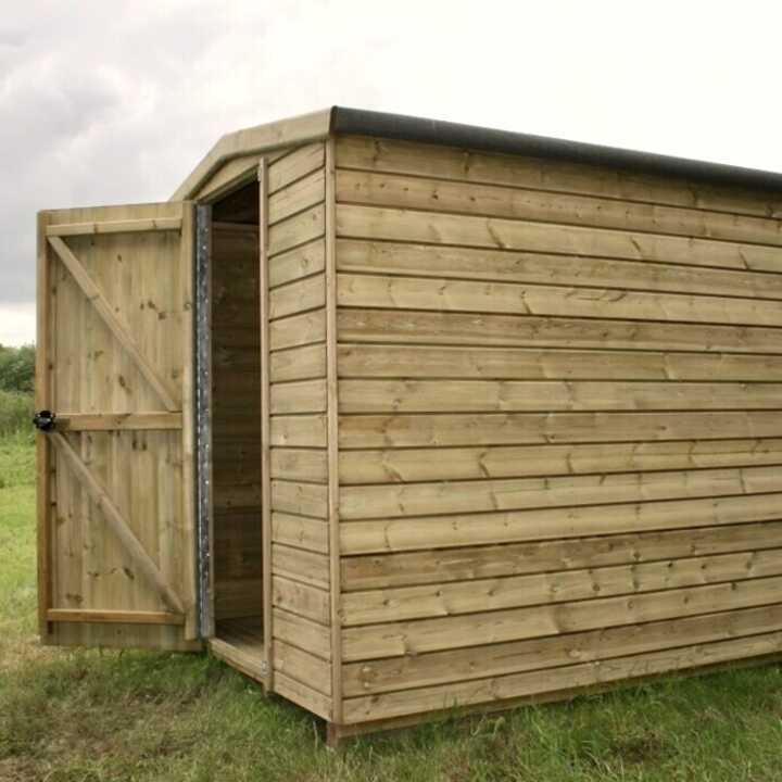 Security shed with an open door, set on a grassy area under a cloudy sky.