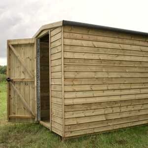 Security shed with an open door, set on a grassy area under a cloudy sky.