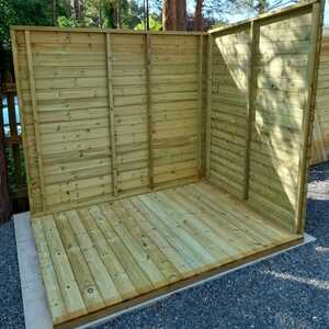A person assembling a wooden shed, focusing on the inner walls.