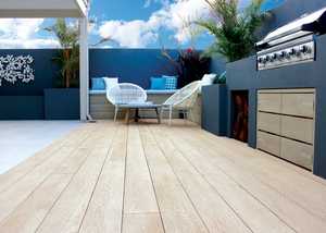 Large patio with garden furniture and a barbeque on millboard decking 