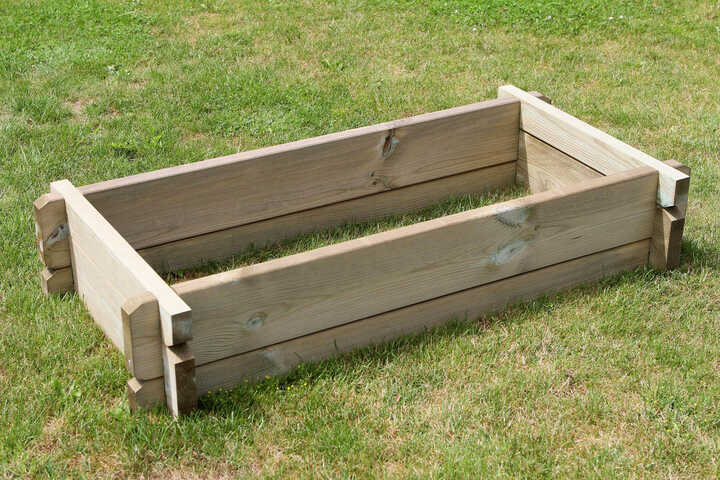 Wooden garden bed frame on grass.