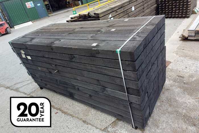 Stack of DURA2 sleepers secured with a strap, on a concrete surface.